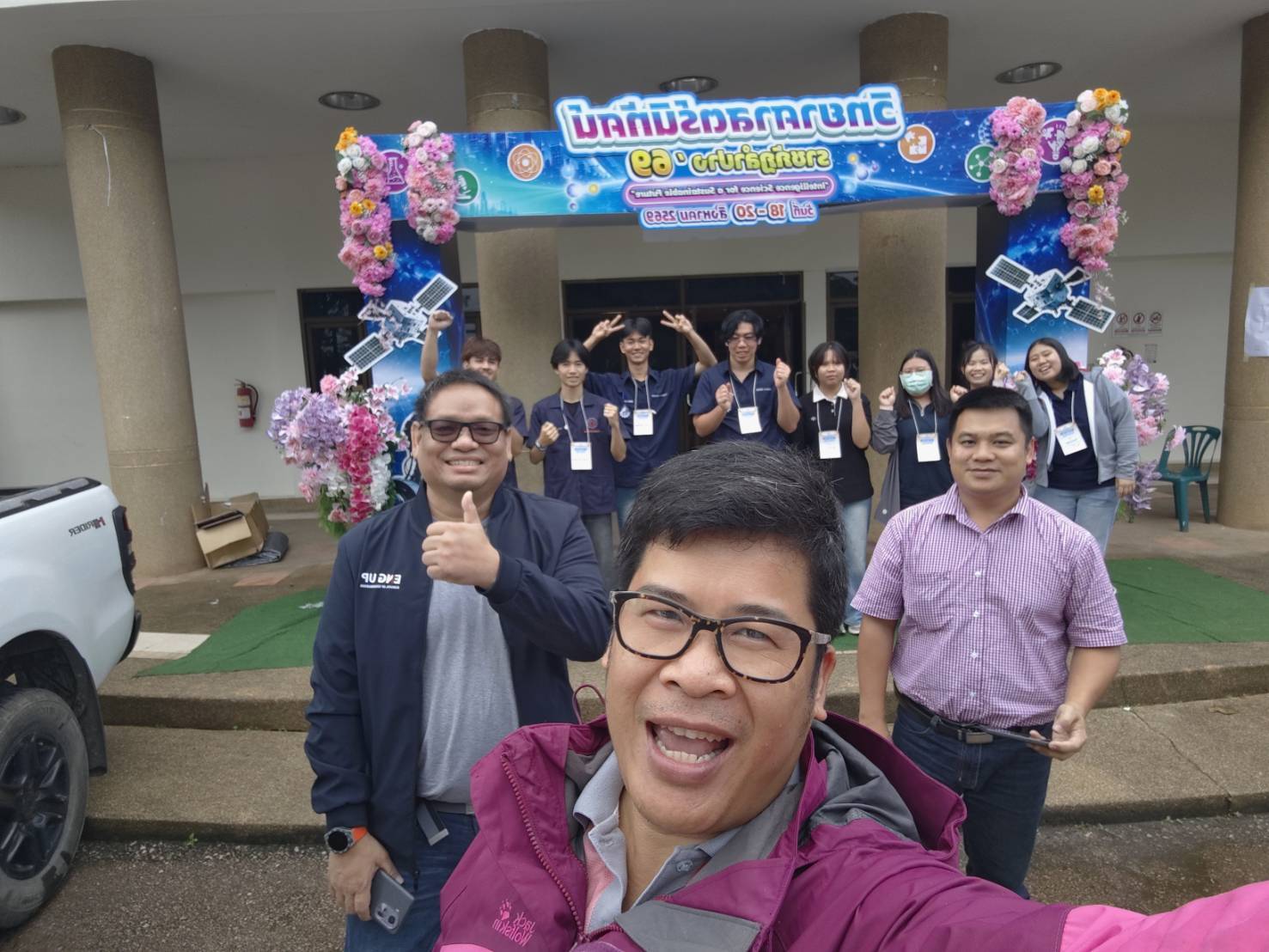 ISL students and academic staff photographed at the entrance arch of the Lampang Rajabhat science exhibition
