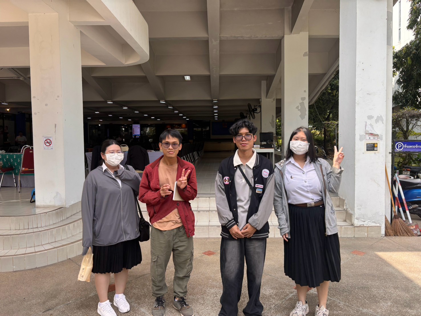 Four ISL students photographed outside the venue at Chiang Mai University during the Study in Japan Fair 2026