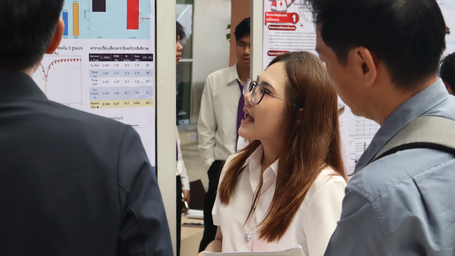 Napaphat Rueangwong explaining her results chart to two judges in front of her project poster