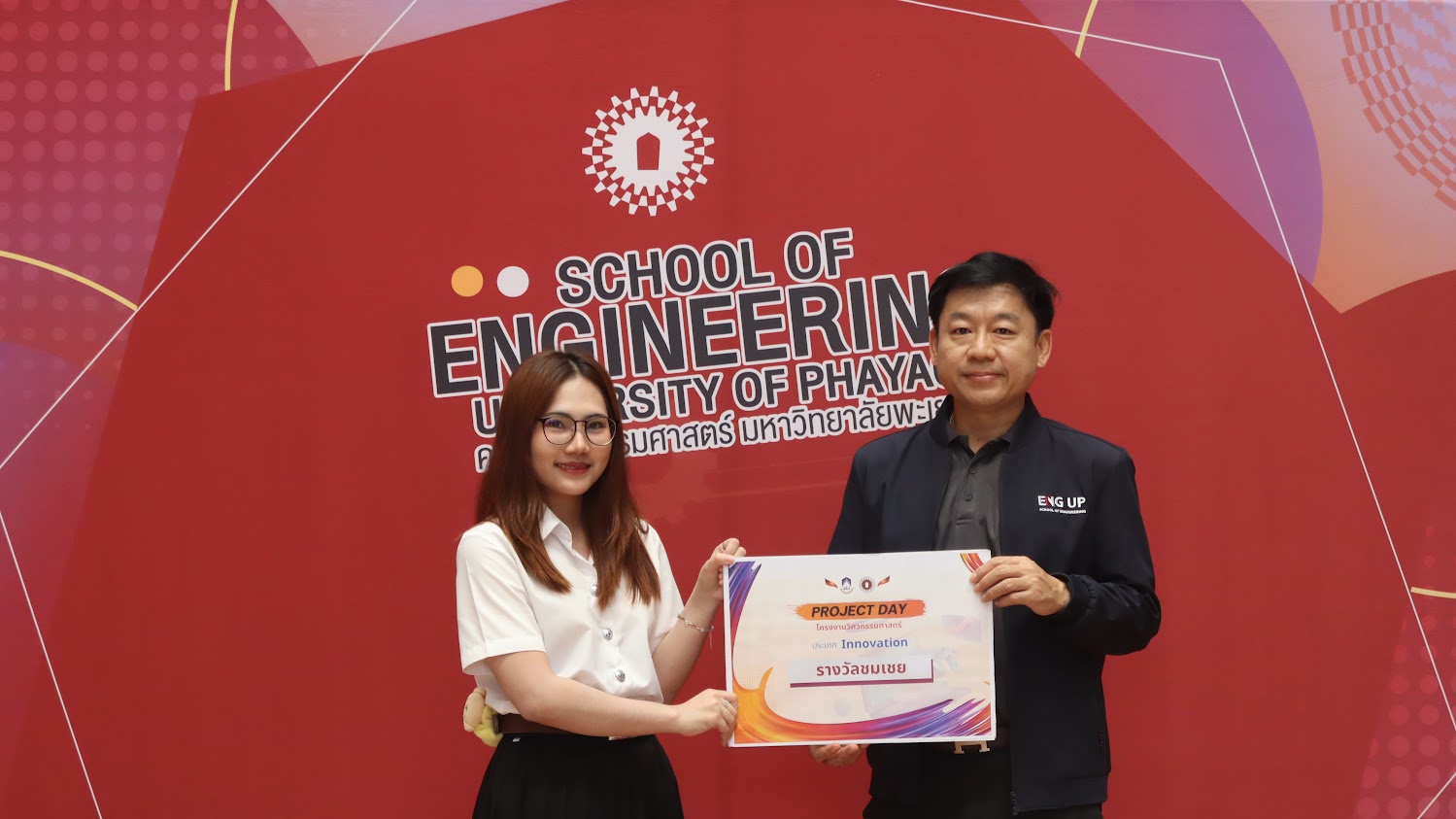 Napaphat Rueangwong with a faculty member in front of the School of Engineering, University of Phayao backdrop