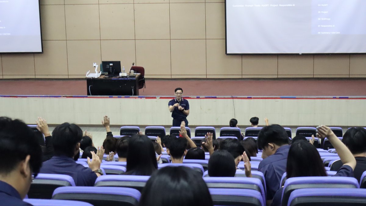 Students raising their hands in response to the speaker during the AI for Engineering Practice session