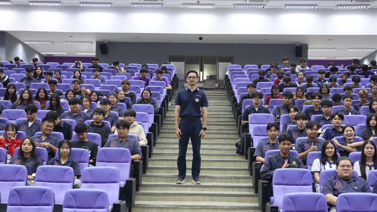 A full lecture hall in room PKY1, with the speaker standing in the aisle among engineering students